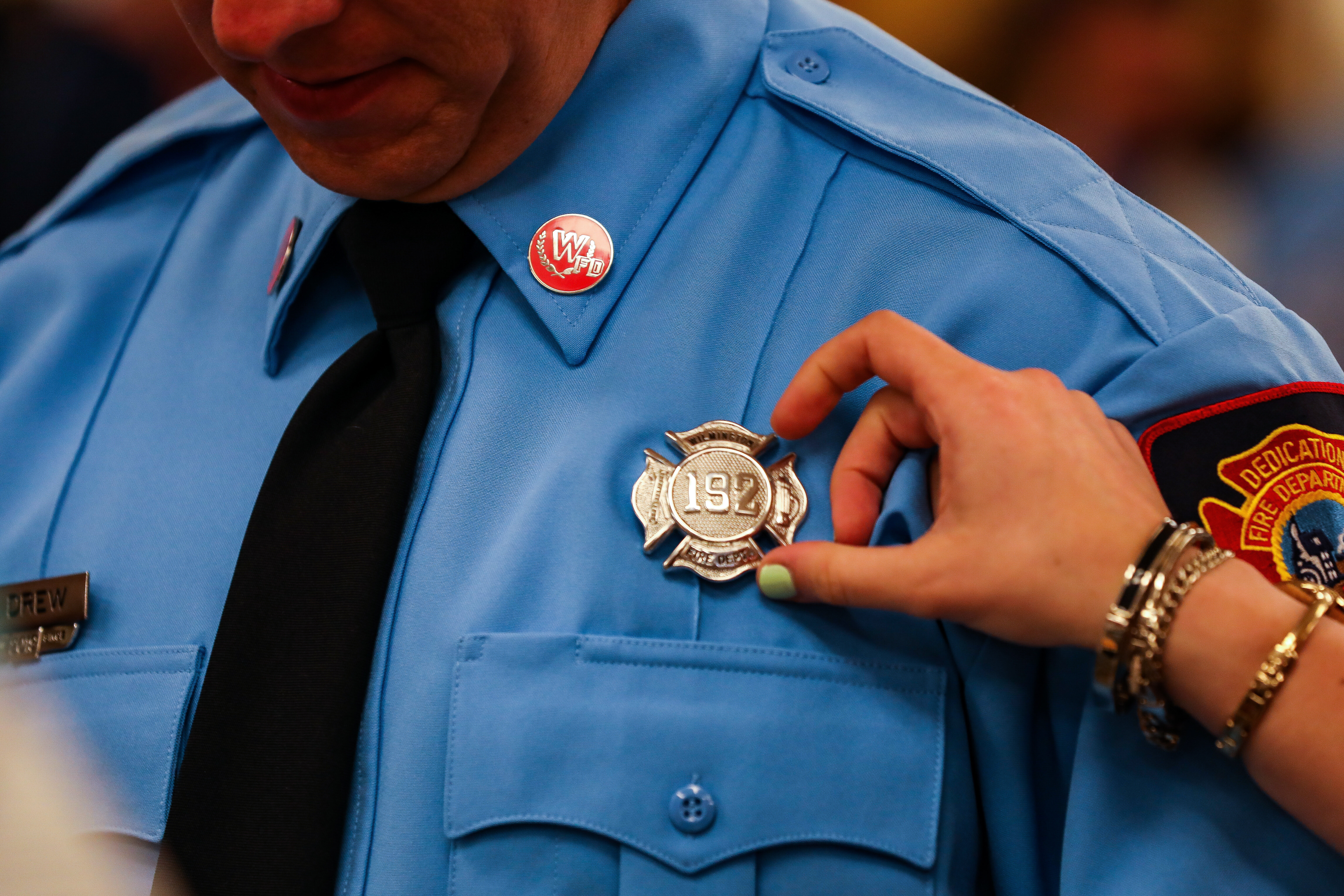 Wilmington fire fighter receives badge at graduation.